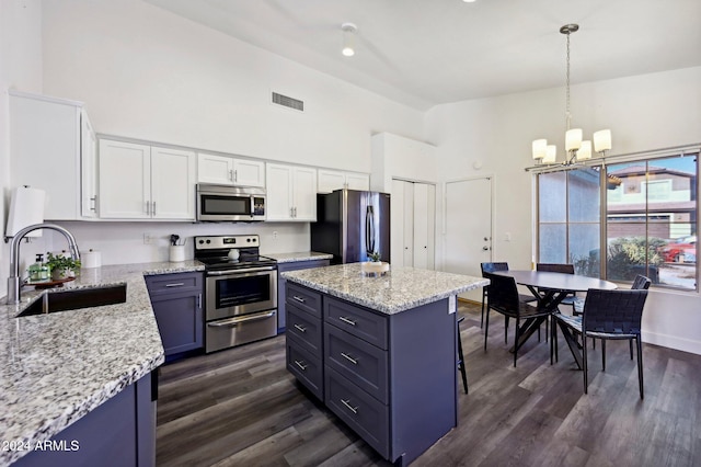 kitchen featuring sink, hanging light fixtures, appliances with stainless steel finishes, dark hardwood / wood-style flooring, and white cabinetry