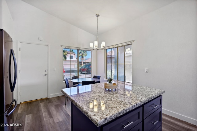 kitchen featuring stainless steel refrigerator, a kitchen island, dark wood-type flooring, and vaulted ceiling