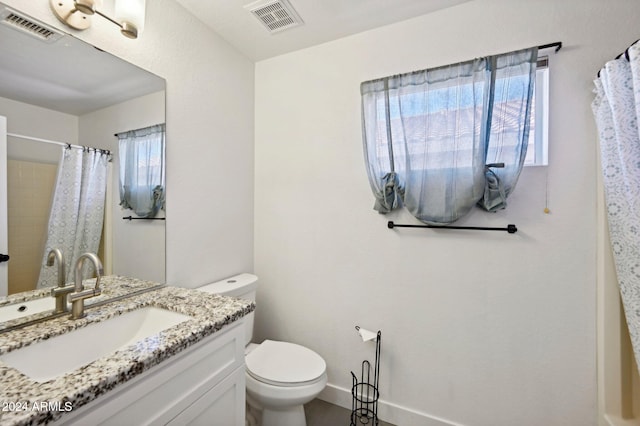 bathroom featuring a shower with curtain, vanity, and toilet