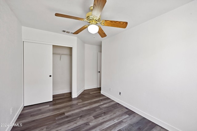 unfurnished bedroom featuring ceiling fan, dark hardwood / wood-style floors, and a closet