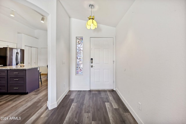 foyer featuring dark wood-type flooring and lofted ceiling