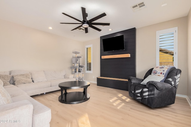 living room with light hardwood / wood-style flooring and ceiling fan