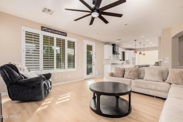 living room featuring light hardwood / wood-style floors and ceiling fan