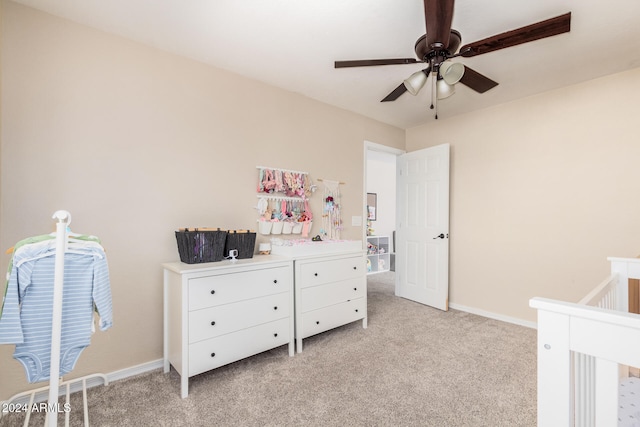 carpeted bedroom with ceiling fan and a nursery area