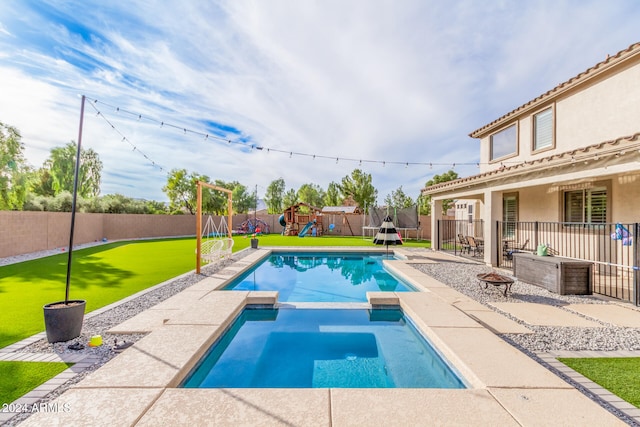 view of pool with a patio area and a yard