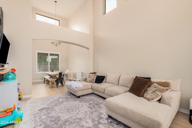 living room featuring hardwood / wood-style floors, a notable chandelier, and high vaulted ceiling