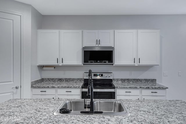 36257 W San Clemente Ave, Maricopa, AZ 85138 - kitchen with white cabinets, a sink, light stone countertops, and appliances with stainless steel finishes