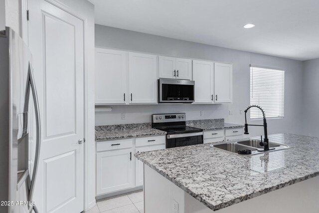 36257 W San Clemente Ave, Maricopa, AZ 85138 - kitchen with light tile patterned floors, a sink, light stone counters, white cabinets, and appliances with stainless steel finishes
