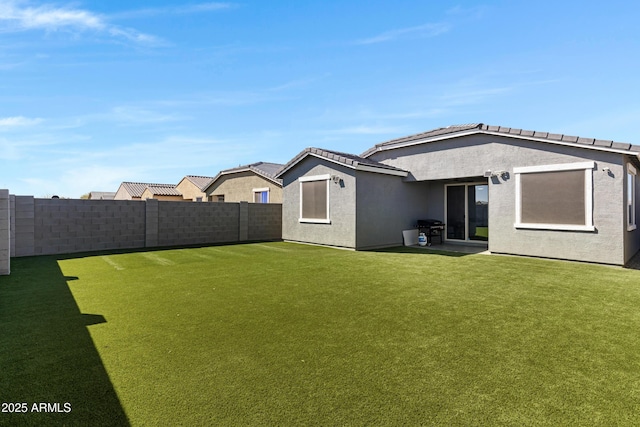 36257 W San Clemente Ave, Maricopa, AZ 85138 - back of house featuring a fenced backyard, a tile roof, stucco siding, and a yard