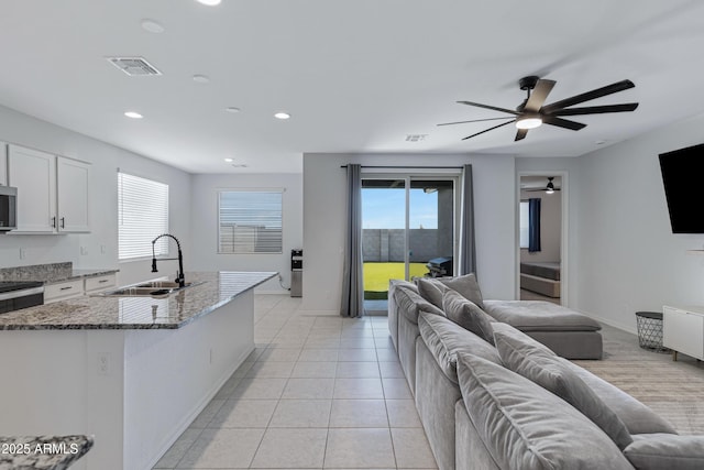 36257 W San Clemente Ave, Maricopa, AZ 85138 - kitchen with a sink, open floor plan, dark stone countertops, visible vents, and ceiling fan