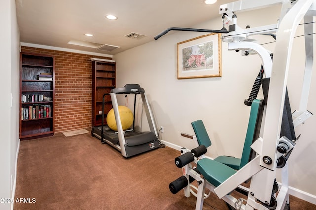 exercise area with carpet, visible vents, brick wall, and recessed lighting