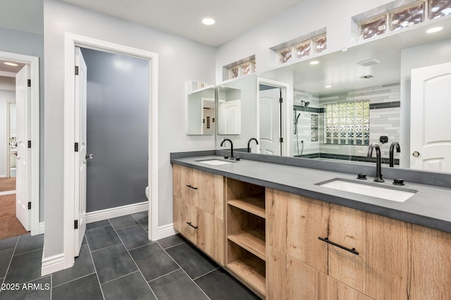 bathroom featuring double vanity, a shower stall, a sink, and tile patterned floors