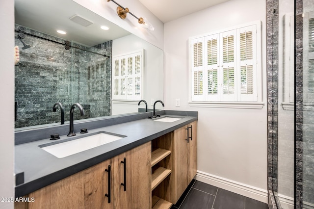 full bath with a stall shower, double vanity, a sink, and tile patterned floors