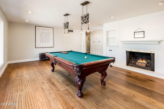 playroom featuring a fireplace, wood finished floors, visible vents, built in features, and baseboards