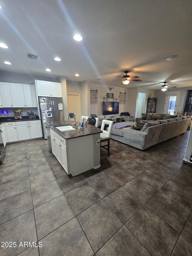 kitchen featuring appliances with stainless steel finishes, sink, a center island with sink, and white cabinets