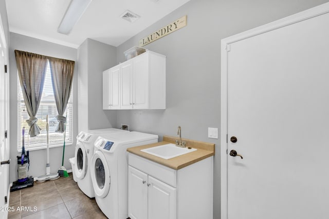 clothes washing area with cabinets, sink, tile patterned floors, and independent washer and dryer