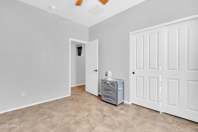 unfurnished bedroom with light tile patterned flooring, ceiling fan, and a closet