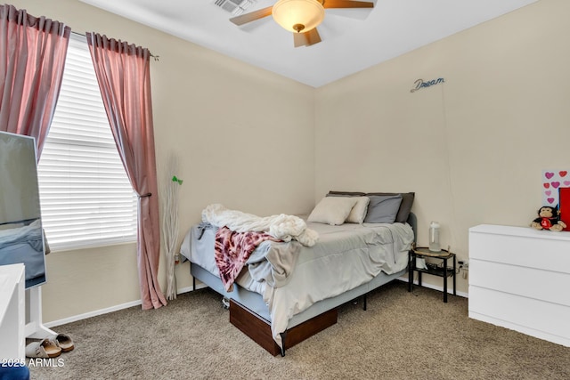 carpeted bedroom with multiple windows and ceiling fan