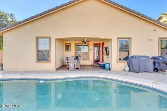 rear view of property featuring ceiling fan and a patio area