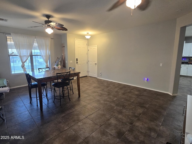 tiled dining space with ceiling fan