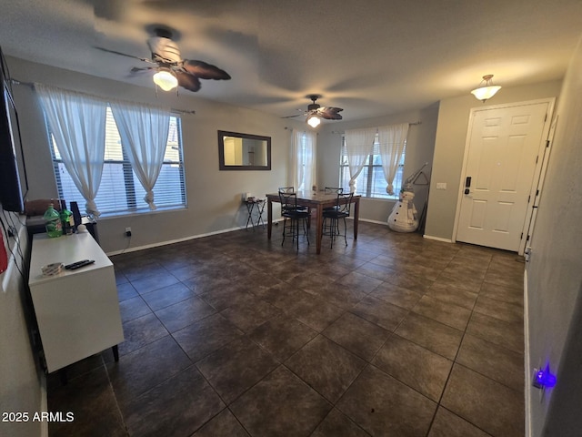 dining room featuring ceiling fan and dark tile patterned flooring