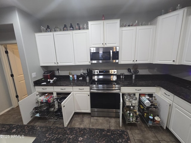 kitchen featuring dark tile patterned flooring, stainless steel appliances, and white cabinets