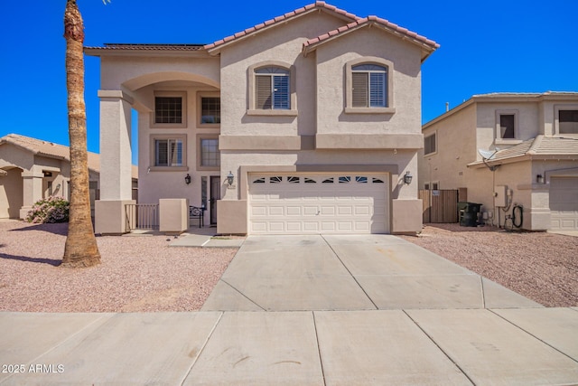 mediterranean / spanish home with an attached garage, a gate, stucco siding, and driveway