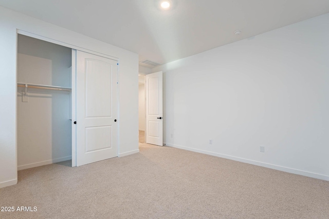 unfurnished bedroom with a closet and light carpet