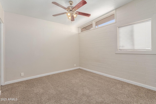 carpeted empty room featuring baseboards and a ceiling fan