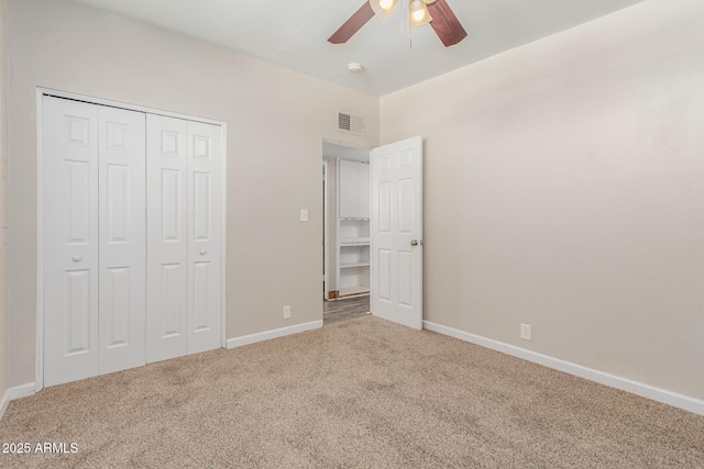 unfurnished bedroom with a closet, carpet flooring, visible vents, and baseboards