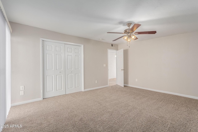 unfurnished bedroom featuring carpet, a closet, ceiling fan, and baseboards