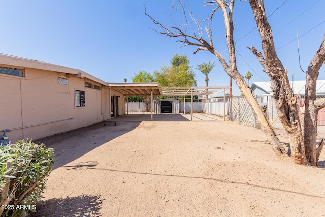 view of yard featuring an attached carport and fence