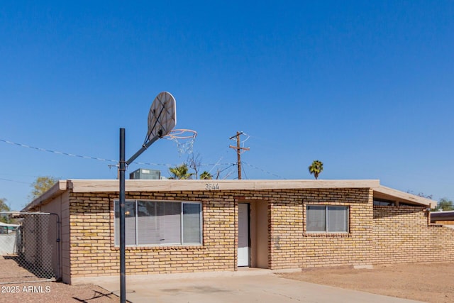 ranch-style house featuring brick siding and fence