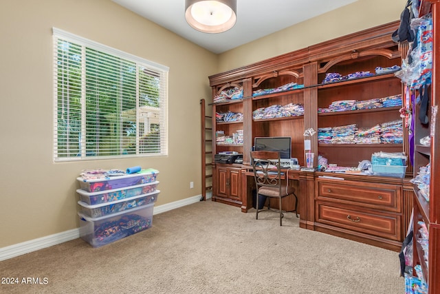 carpeted home office featuring built in desk