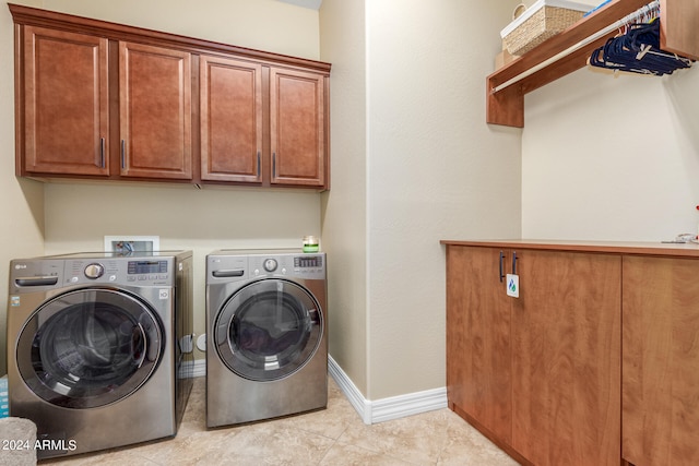 washroom featuring cabinets, light tile patterned floors, and independent washer and dryer