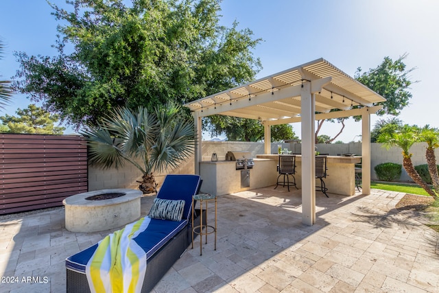 view of patio with exterior bar, a pergola, area for grilling, grilling area, and a fire pit