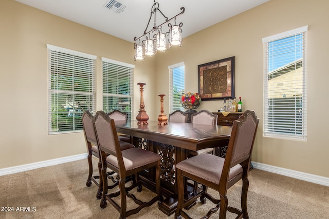 dining space featuring a notable chandelier and carpet floors