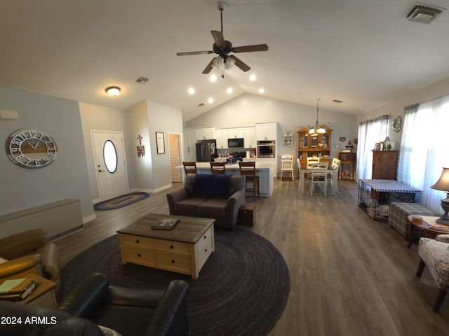 living area featuring dark wood-style flooring, visible vents, vaulted ceiling, baseboards, and ceiling fan with notable chandelier