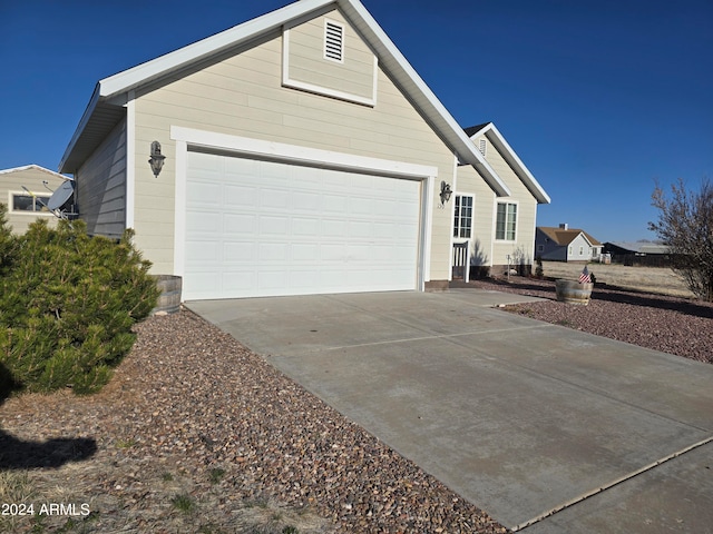 view of side of property with a garage and concrete driveway