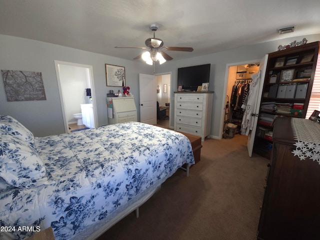 carpeted bedroom featuring a closet, visible vents, a spacious closet, a ceiling fan, and ensuite bath