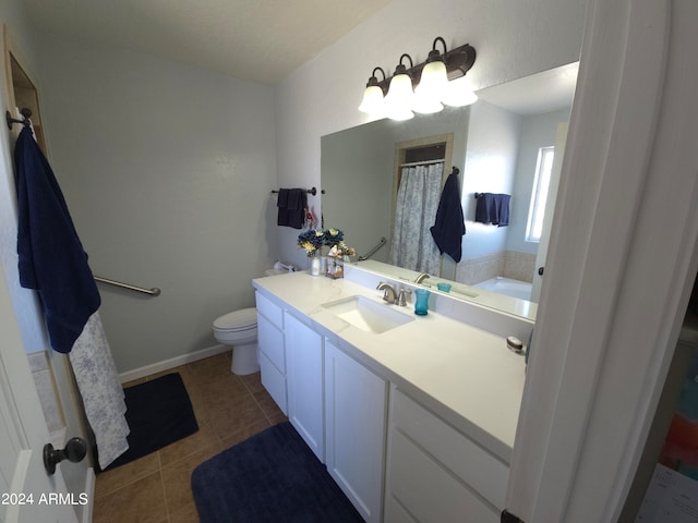 bathroom with toilet, vanity, and tile patterned floors