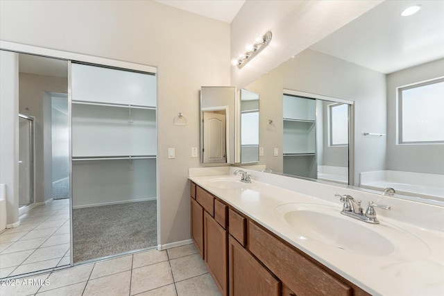 3310 W Chambers St, Phoenix, AZ 85041 - bathroom featuring double vanity, a shower stall, a walk in closet, tile patterned flooring, and a garden tub