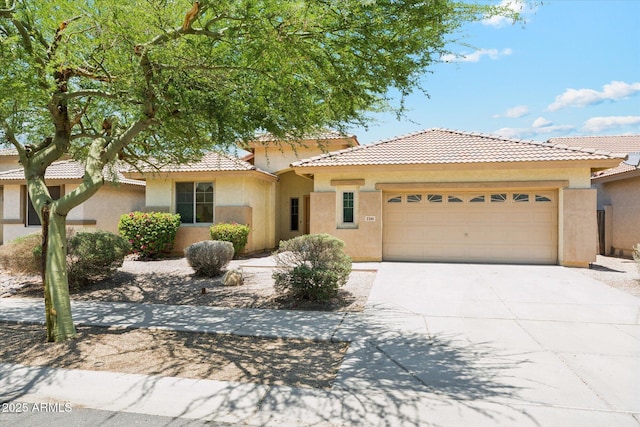3310 W Chambers St, Phoenix, AZ 85041 - view of front of house featuring an attached garage, driveway, stucco siding, and a tile roof