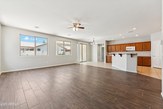 3310 W Chambers St, Phoenix, AZ 85041 - unfurnished living room featuring a ceiling fan, light wood-type flooring, a chandelier, and recessed lighting