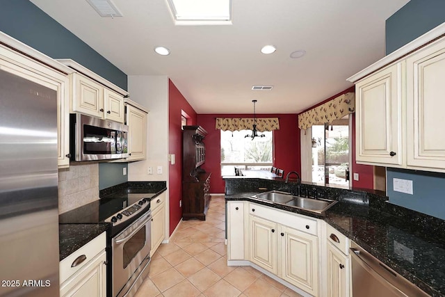 17630 N Somerset Dr, Surprise, AZ 85374 - kitchen with appliances with stainless steel finishes, a sink, cream cabinets, light tile patterned flooring, and recessed lighting