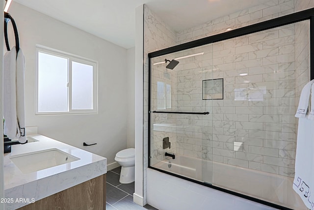 full bathroom featuring vanity, toilet, tile patterned flooring, and combined bath / shower with glass door