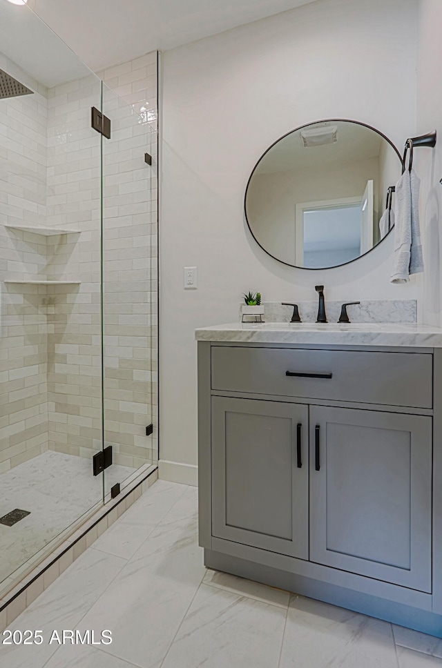 bathroom featuring a shower with door and vanity