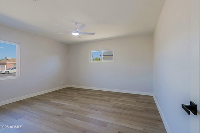 empty room with ceiling fan, light hardwood / wood-style floors, and a wealth of natural light