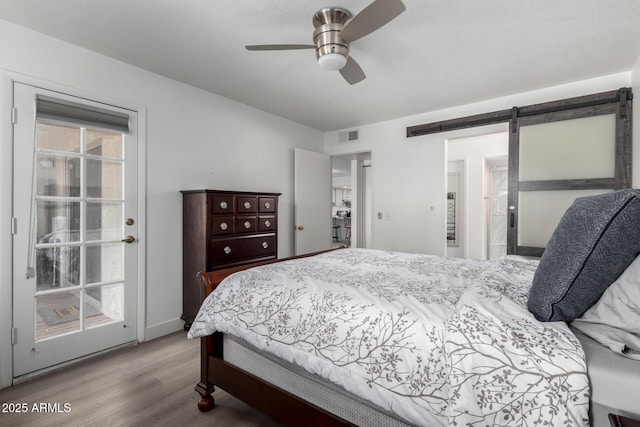 4150 E Cactus Rd Unit 205, Phoenix, AZ 85032 - bedroom with wood finished floors, a barn door, and ceiling fan
