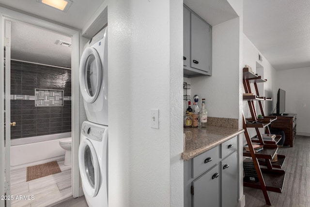 4150 E Cactus Rd Unit 205, Phoenix, AZ 85032 - laundry room with stacked washer and clothes dryer and light wood finished floors